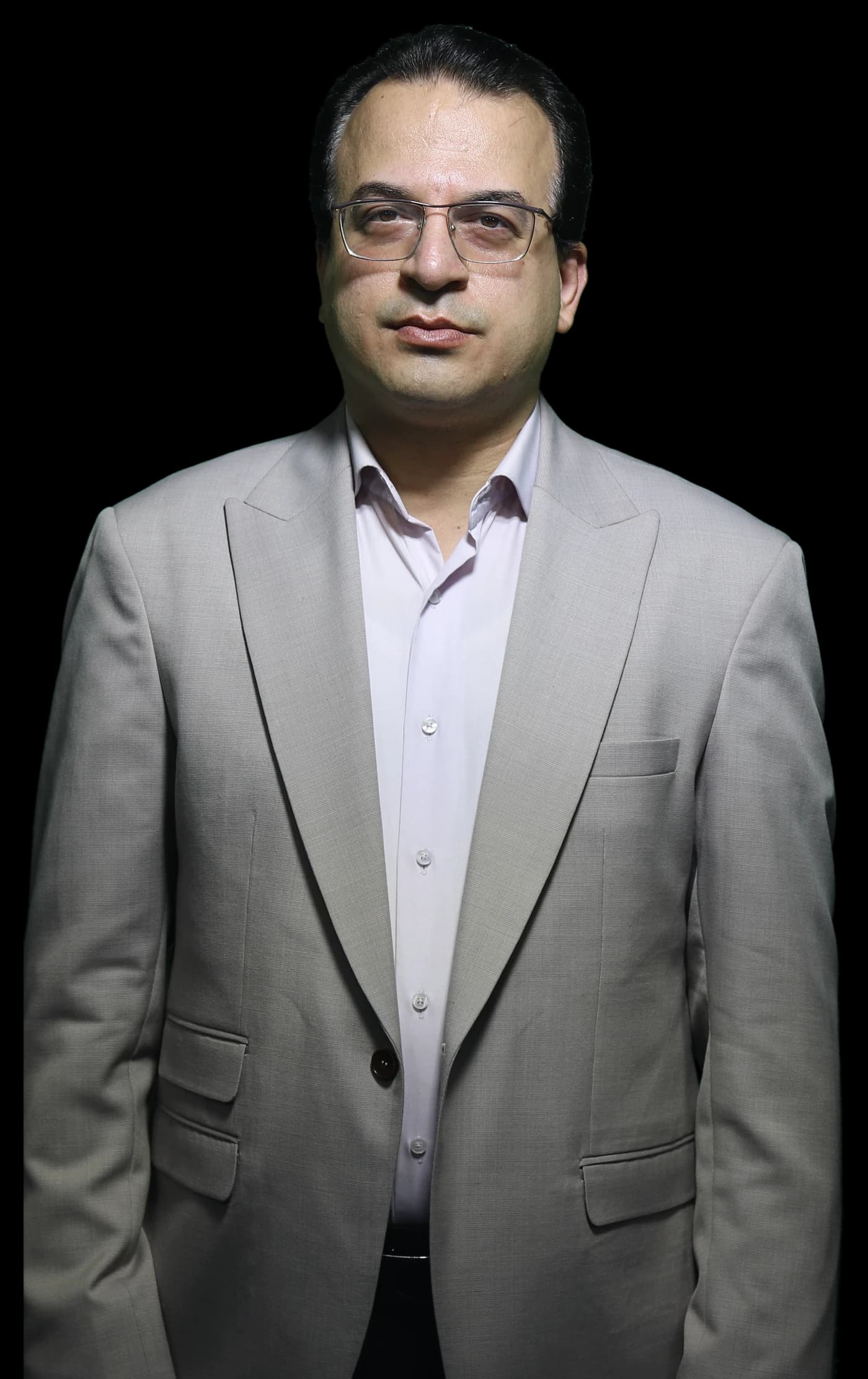 دکتر مجتبی هدایت یعقوبی با کت‌وشلوار طوسی روشن، رو به دوربین